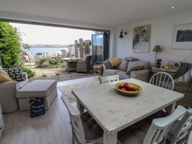 A living room with a dining table and view of the outdoor patio at Mariners Cottage in Bideford