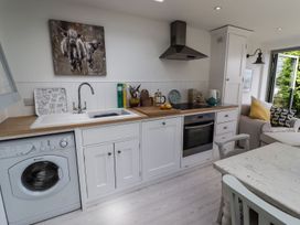 A kitchen with a washing machine and stove at Mariners Cottage in Bideford