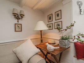 A sitting room with a lamp and decorative items at Mariners Cottage in Bideford