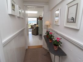 A hallway with flower pots and pictures at Mariners Cottage in Bideford