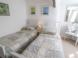 A bedroom with two single beds and a side lamp at Mariners Cottage in Bideford
