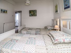 A bedroom with two beds and a lamp at Mariners Cottage in Bideford