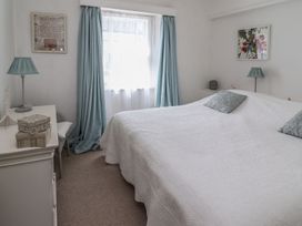 A bedroom with a large bed and decorative items at Mariners Cottage Bideford