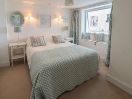 A bedroom with a bed and bedside table at Mariners Cottage in Bideford