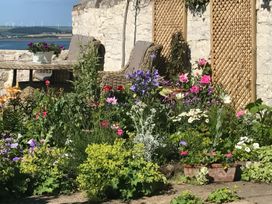 A garden with flowers and seating at Mariners Cottage in Bideford