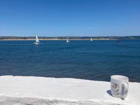 A view of sailing boats on the water with a mug on the shore at Mariners Cottage in Appledore