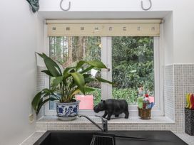 A kitchen with a plant and a figurine on the windowsill at The Old Telephone Exchange in Exeter