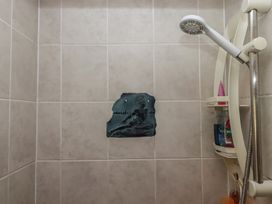 A shower with a tile wall and a decorative plaque at The Old Telephone Exchange in Exeter
