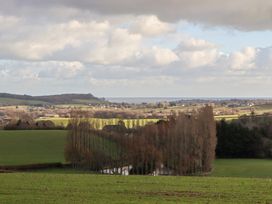 A landscape view with fields, trees, and a body of water at The Old Telephone Exchange in Exeter