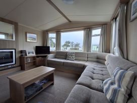 A living room with a sofa and television at Caravan
