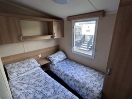 A bedroom with two beds and a window in Caravan