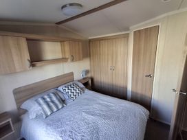 A bedroom with a bed and a bedside table at Caravan