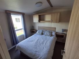 A bedroom with a bed and bedside tables at Caravan 