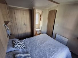 A bedroom with a bed and adjoining bathroom at Caravan