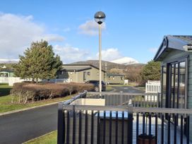 An outdoor area with mobile homes and trees at Caravan in 