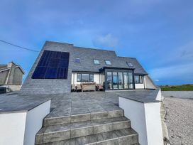 A house with solar panels and outdoor seating at Pengarnedd in Amlwch