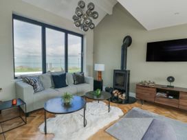 A living room with a sofa and a television at Pengarnedd in Amlwch