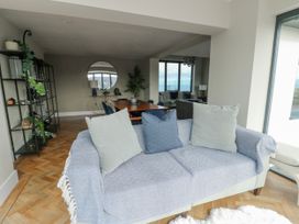 A living room with a sofa and dining area at Pengarnedd in Amlwch