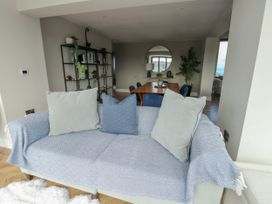 A living room with a sofa and dining area at Pengarnedd in Amlwch