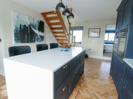 A kitchen with a table and chairs and a staircase at Pengarnedd in Amlwch