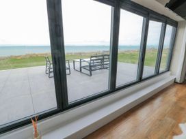 A living room with a view of the patio and sea at Pengarnedd Amlwch