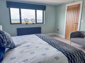 A bedroom with a bed and view of the ocean at Pengarnedd in Amlwch