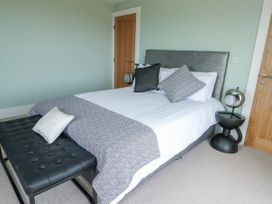 A bedroom with a bed and a bench at Pengarnedd Amlwch