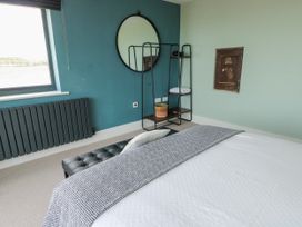A bedroom with a bed and a mirror at Pengarnedd Amlwch