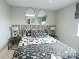 A bedroom with a bed and mirrors at Pengarnedd in Amlwch