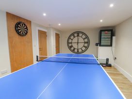 A game room with a table tennis table and dartboard at Pengarnedd in Amlwch