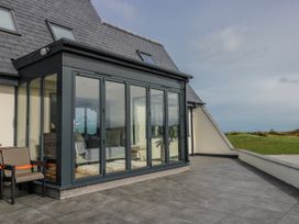 A conservatory with chairs and a sofa at Pengarnedd in Amlwch