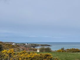 A view of the sea and houses along the coast at Pengarnedd in Amlwch
