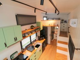 A kitchen with cabinets and a refrigerator at The Tiny Home