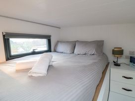 A bedroom with a bed, pillows, and a window at The Tiny Home