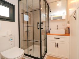 A bathroom with a shower and sink at The Tiny Home