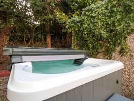 A hot tub with water and a cover in a garden at The Tiny Home