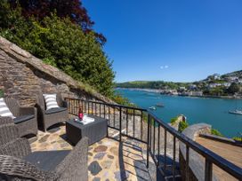 An outdoor seating area overlooking the water at Bell Cottage in Dartmouth