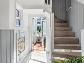 A hallway with a staircase and a door to a conservatory at Bell Cottage Dartmouth