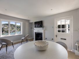 A living room with a fireplace and a view at Bell Cottage in Dartmouth