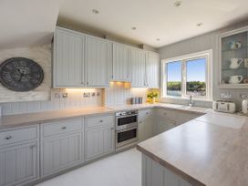A kitchen with cabinets and a window overlooking the harbor at Bell Cottage in Dartmouth