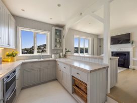 A kitchen with a window and cabinets at Bell Cottage in Dartmouth