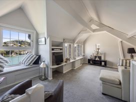 A living room with a window seat and television at Bell Cottage in Dartmouth