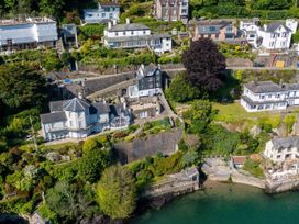 A view of houses and gardens along a waterfront at Bell Cottage in Dartmouth
