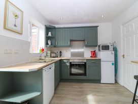 A kitchen with appliances and cabinetry at Meadow View in Kinmel Bay