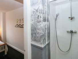 A bathroom with a shower and towel hooks at Meadow View in Kinmel Bay