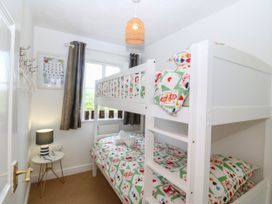 A bedroom with a bunk bed and decorative wall art at Meadow View in Kinmel Bay