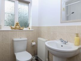 A bathroom with a toilet, washbasin, and decorative items at Meadow View in Kinmel Bay