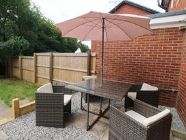 A garden area with a table and chairs under an umbrella at Meadow View in Kinmel Bay