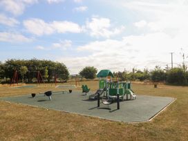 A playground with swings and play equipment at Meadow View in Kinmel Bay