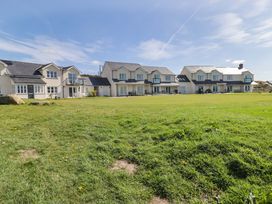 A row of houses with a grassy area at Ty Mor Newport, Pembrokeshire